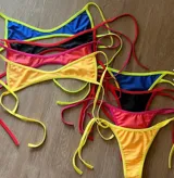 Bikini de dos piezas color amarillo liso, con corpiño triangular y bombacha de corte bajo con tiras finas ajustables en los laterales.