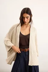 Saco tejido oversize color beige, confeccionado con mezcla de algodón y acrílico, de manga caída y largo por debajo de la cadera.