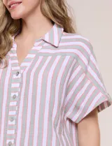 Camisa de algodón con rayas verticales en tonos verde, rosado y blanco. Tiene mangas cortas amplias, escote en V con solapa y botones frontales, y detalle de nudo en el bajo.