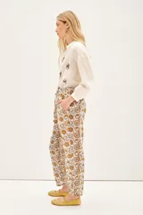 Babucha de voile de algodón con estampado tipo paisley en tonos tierra. Presenta un diseño holgado con lazos internos en el ruedo y botones para ajustar el largo.
