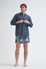 Short de baño azul marino con estampado de hojas tropicales en tonos celeste y naranja, con cordón ajustable naranja.