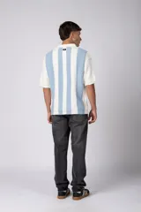 Chomba de punto con diseño de rayas verticales en color celeste y blanco, cuello tipo polo con cierre de botones y mangas cortas.