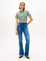 Remera de manga corta con cuello redondo y ribete en color verde oscuro. Presenta un patrón de rayas horizontales alternadas en blanco y verde. Tiene un pequeño logo circular bordado en blanco en el centro del pecho.