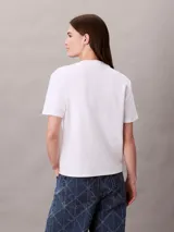 Remera Calvin Klein de algodón interlock color blanco, con cuello redondo, manga corta y emblema geométrico bordado en el pecho.