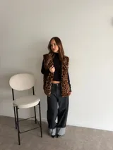 Chaleco de piel sintética con estampado animal print de leopardo, sin mangas y diseño largo.