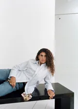 Camisa de corte recto con diseño de rayas verticales en tonos celestes y blancos. Presenta cuello camisero con solapas amplias, cierre frontal de botones ocultos bajo tapeta y mangas largas con puños abotonados.