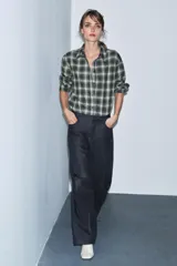 Camisa de corte oversize confeccionada en algodón, con estampado de cuadros en tonos verde, negro y blanco. Presenta cuello solapa, cierre frontal con botones, manga larga con puños y bajo asimétrico.