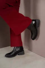 Bota corta de cuero marrón con panel trasero de gamuza en tono más oscuro, suela de goma negra y taco cuadrado bajo.