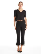 Blusa negra de corte corto con escote en V, mangas cortas con sutil efecto abullonado en los hombros y ruedo decorado con flecos de cuentas negras.