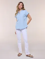 Blusa blanca de algodón y viscosa, con cuello camisero, escote en V y mangas cortas con vuelta.