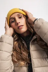 Gorro de lana tejido color lila con etiqueta negra con logo en el frente.