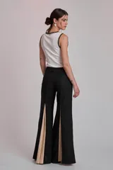 Remera negra sin mangas, tipo musculosa, con escote redondo y ribetes blancos con apliques de perlas en el contorno del cuello y las sisas.