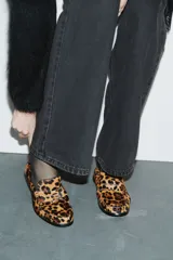 Mocasines de cuero con textura de pelo y estampado de leopardo, con diseño clásico de lengüeta decorativa y costuras frontales.