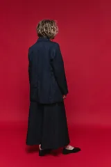 Blazer azul marino con cuello alto y cierre frontal cruzado.