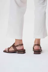 Sandalias de cuero azul con tiras cruzadas y hebilla lateral. Presenta una tira delantera color rosa claro.