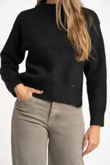 Sweater de punto color negro confeccionado en mezcla de lana lambswool y nylon. Presenta cuello alto tipo polera, manga larga y terminaciones acanaladas en puños y bajo.