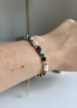Pulsera de acero dorado con cuentas de vidrio de colores y perlas cultivadas.