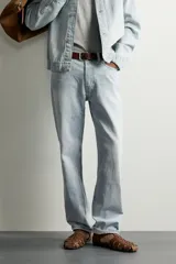 Jeans de corte recto color celeste claro, con tiro medio, diseño de cinco bolsillos, efecto lavado y bajo con acabado irregular deshilachado.