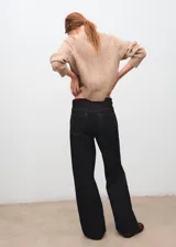 Sweater de punto color tostado, de cuello redondo y mangas largas con diseño texturizado de ochos y detalles calados.