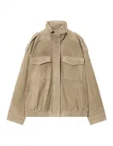 Chaqueta de gamuza en color marrón oscuro, con cuello alto, cierre frontal oculto y bolsillos tipo cargo en el pecho. Presenta un diseño de corte holgado con detalles de charreteras en los hombros.