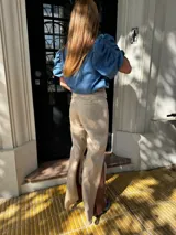 Pantalón sastrero de lino color marrón, de corte recto y tiro alto, con un bordado de caballo en el bolsillo. Presenta costuras en contratono.