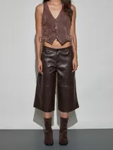 Bermuda estilo culotte confeccionada en cuerina color marrón chocolate, con diseño holgado y costuras horizontales decorativas en las piernas.