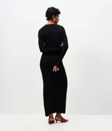 Vestido midi de punto acanalado color bordó, con cuello redondo y mangas largas. Presenta un diseño ajustado en el torso que se extiende hacia una falda con caída fluida.