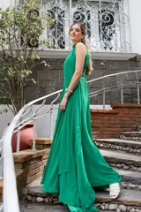 Vestido largo de gasa color verde esmeralda, con cuello halter, drapeado en el corpiño y falda plisada. Incluye lazos a los costados del cuello que permiten múltiples formas de uso.