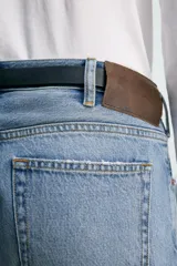Jeans de mezclilla rígida de algodón, color azul claro con efecto lavado y ligero desgaste. De tiro medio, corte recto desde la cadera hasta la rodilla y ligeramente acampanado en el bajo (bootcut). Cierre frontal con botonadura y cinco bolsillos.