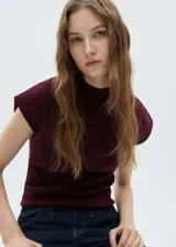 Jersey de punto fino color bordó, con cuello perkins y mangas cortas. Presenta un diseño entallado al cuerpo.