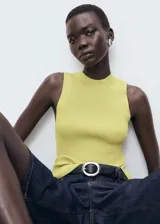 Top de punto de canalé color amarillo lima, sin mangas, con cuello alto y diseño entallado.