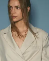 Collar de cadena con eslabones irregulares de diseño artesanal, con cierre frontal tipo barra y aro. La pieza permite diversas formas de uso, incluyendo como collar, pulsera o accesorio de espalda.