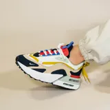 Championes Nike Air Max Furyosa de diseño vanguardista y deportivo. Presentan una estructura multicapa con combinación de colores blanco, beige, azul marino, amarillo, rojo y verde menta. Incluyen unidad de aire visible en la entresuela, sistema de cordones doble y detalle de tirador en el talón.