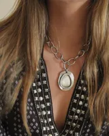 Collar plateado con cadena de eslabones grandes y dije irregular con centro liso.