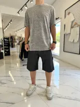 Bermuda baggy de jean negro, con costuras visibles en blanco y diseño holgado.