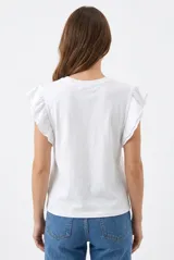 Remera color beige con cuello redondo y mangas cortas adornadas con volados fruncidos.