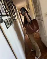 Bolso tote negro de cuero vacuno con costuras a la vista.