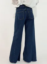 Pantalon de jean azul oscuro, de corte wide leg con botamanga deshilachada y tiro medio.