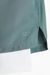 Short deportivo de doble capa en tejido funcional con tecnología DryMove para absorción de sudor. Cuenta con calza interna integrada con bolsillo, cintura elástica con cordón oculto, bolsillos laterales y aberturas en el bajo.