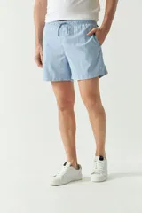 Short de baño liso de color celeste, con cintura elástica ajustable mediante cordón, dos bolsillos laterales y uno trasero. Confeccionado en tejido ligero de secado rápido con logo bordado en la pierna.