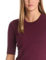 Buzo de tejido fino en color azul marino, con cuello redondo y mangas cortas con puños acanalados.