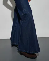 Jean de denim azul oscuro con diseño acampanado y costuras decorativas a contratono en las piernas.