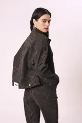 Campera de jean con estampado animal print en tonos marrones y negros, corte cropped y bolsillos delanteros.