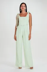 Mono largo de acetato crepé color verde menta, con escote cuadrado, tirantes anudados en los hombros, cintura ceñida con detalle de lazo y pantalón de corte recto y holgado.