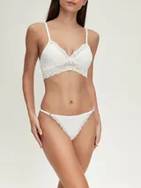 Colaless de tiro bajo color negro, con bordes de encaje floral en la parte delantera y trasera. Los laterales son tiras finas ajustables con argollas metálicas.