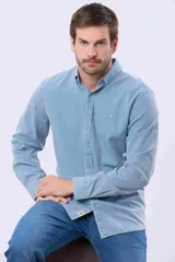 Camisa de manga larga color gris oscuro, con efecto lavado, cuello camisero con botones y cierre frontal abotonado.