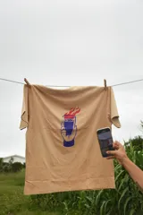 Remera blanca de manga corta con estampado de un vaso con llamas.