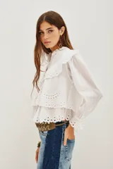 Camisa de algodón con diseño de encaje bordado, cuello mao, cierre frontal de botones y mangas largas con puños con volados.