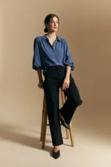 Camisa de manga larga color celeste, con cuello clásico, cierre frontal con botones y puños elastizados con volados. Presenta un diseño fluido con detalle de vainilla en la espalda.