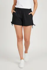 Short negro de poliamida, con cintura elástica, corte holgado y frunces laterales con cordón ajustable.